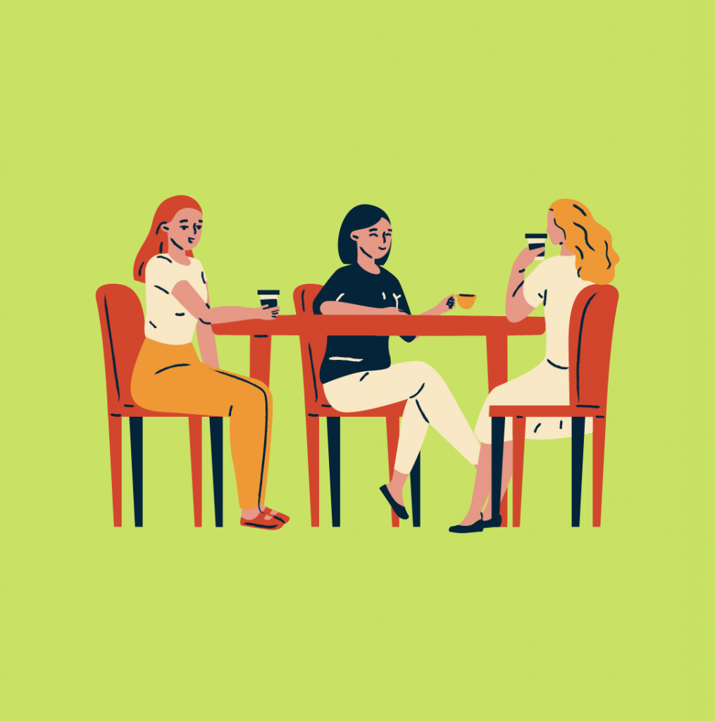 Three people sitting at a table talking and having coffee together